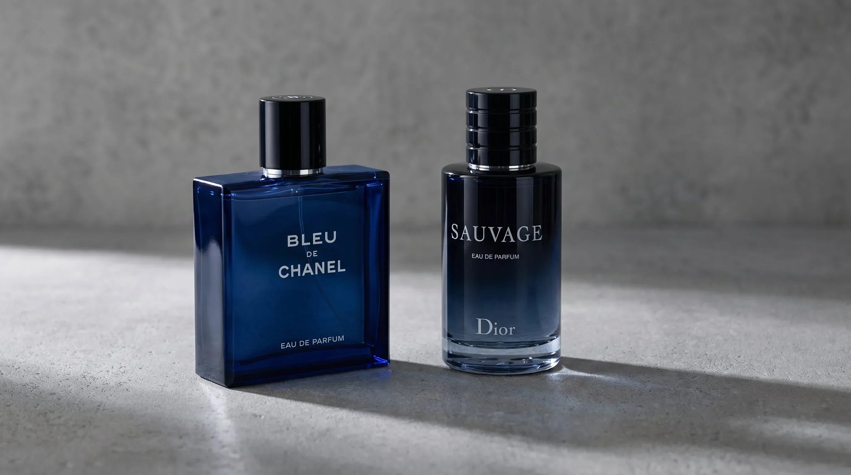 Bleu de Chanel EDP and Dior Sauvage EDP side by side on gray concrete surface