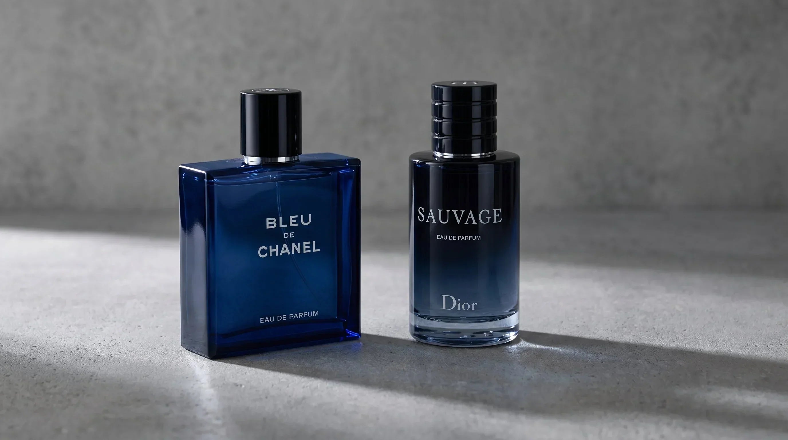 Bleu de Chanel EDP and Dior Sauvage EDP side by side on gray concrete surface