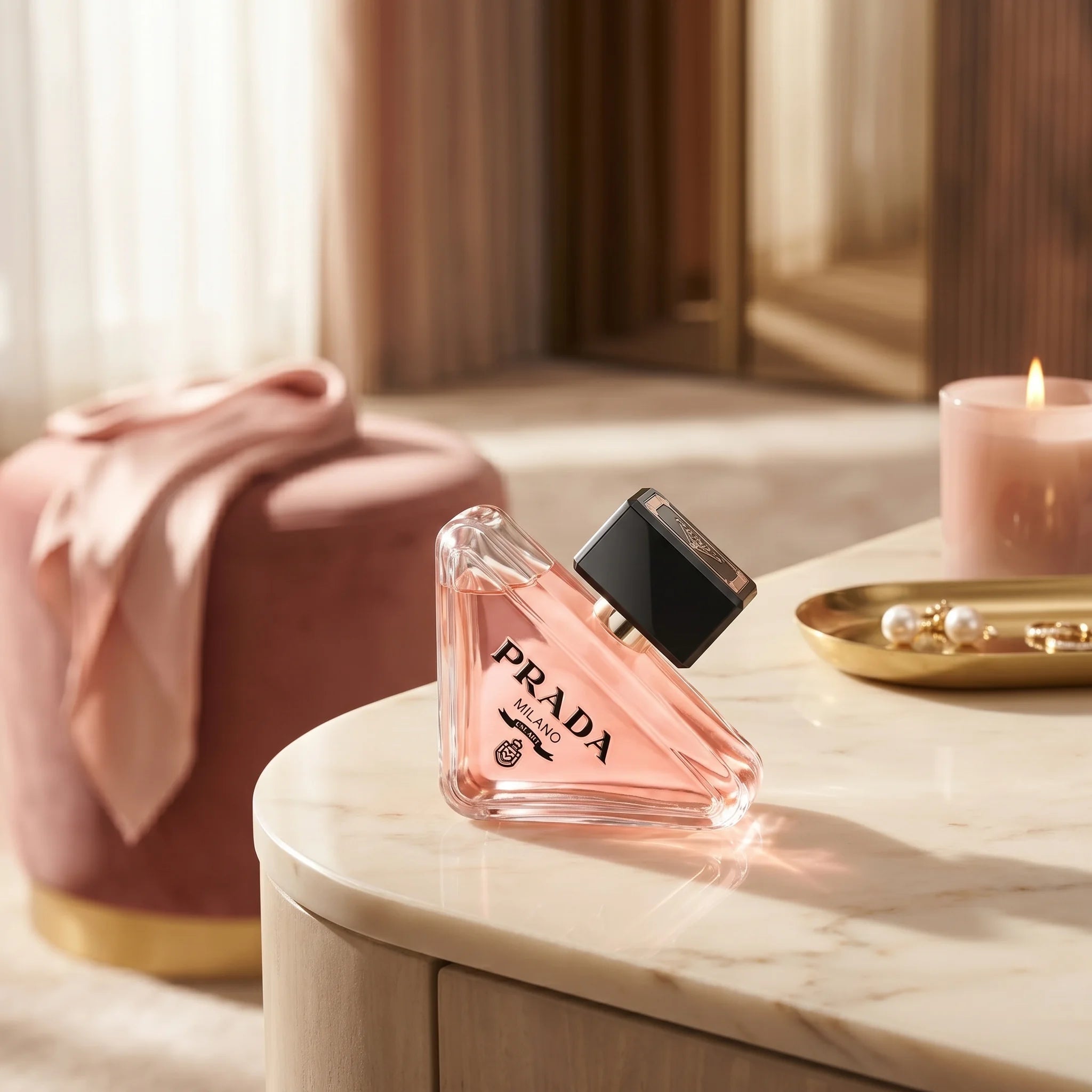 Prada Paradoxe Eau de Parfum on a cream marble vanity with silk scarf and pearl earrings in a sunlit luxury dressing room