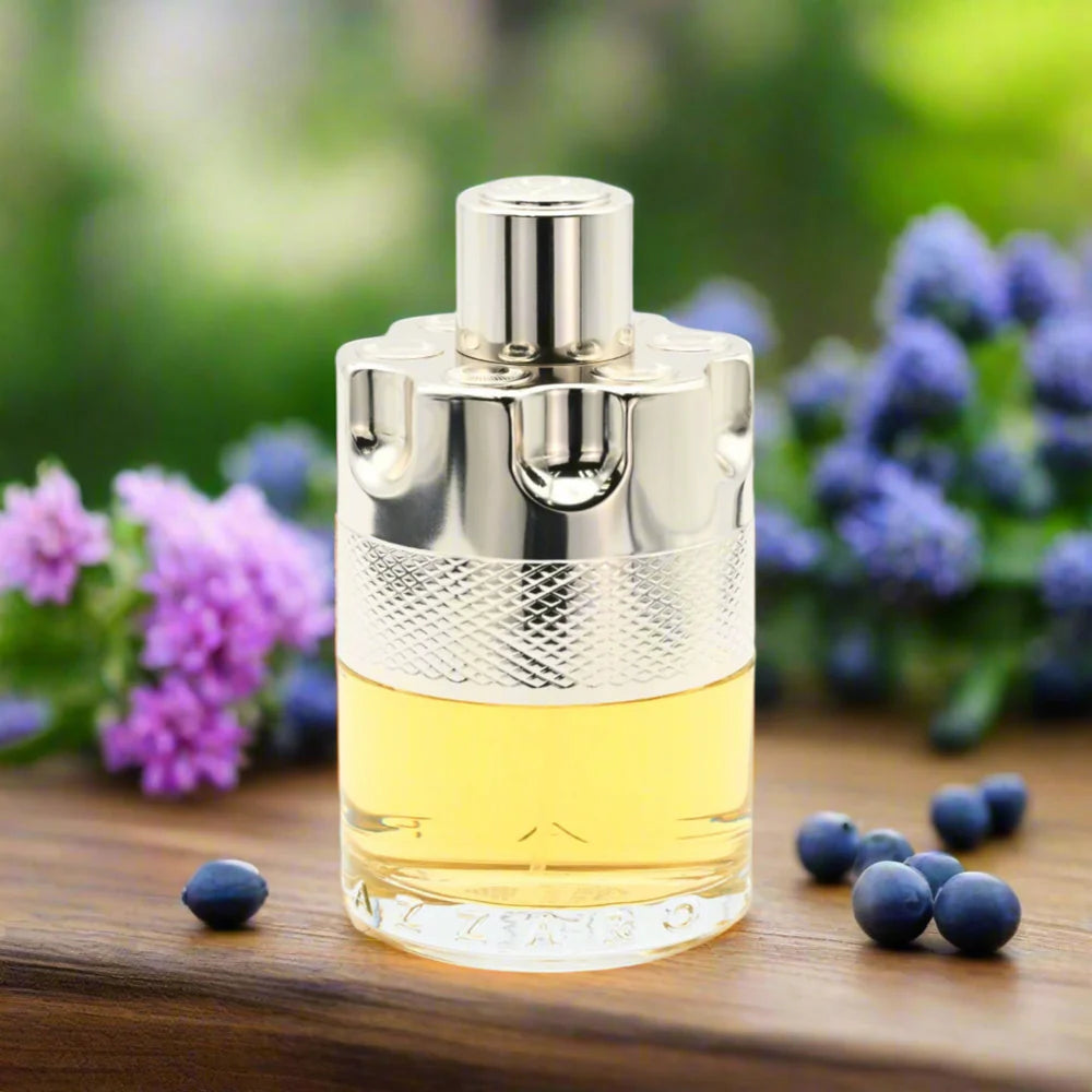 Perfume bottle with silver cap on a wooden surface with flowers and berries in the background