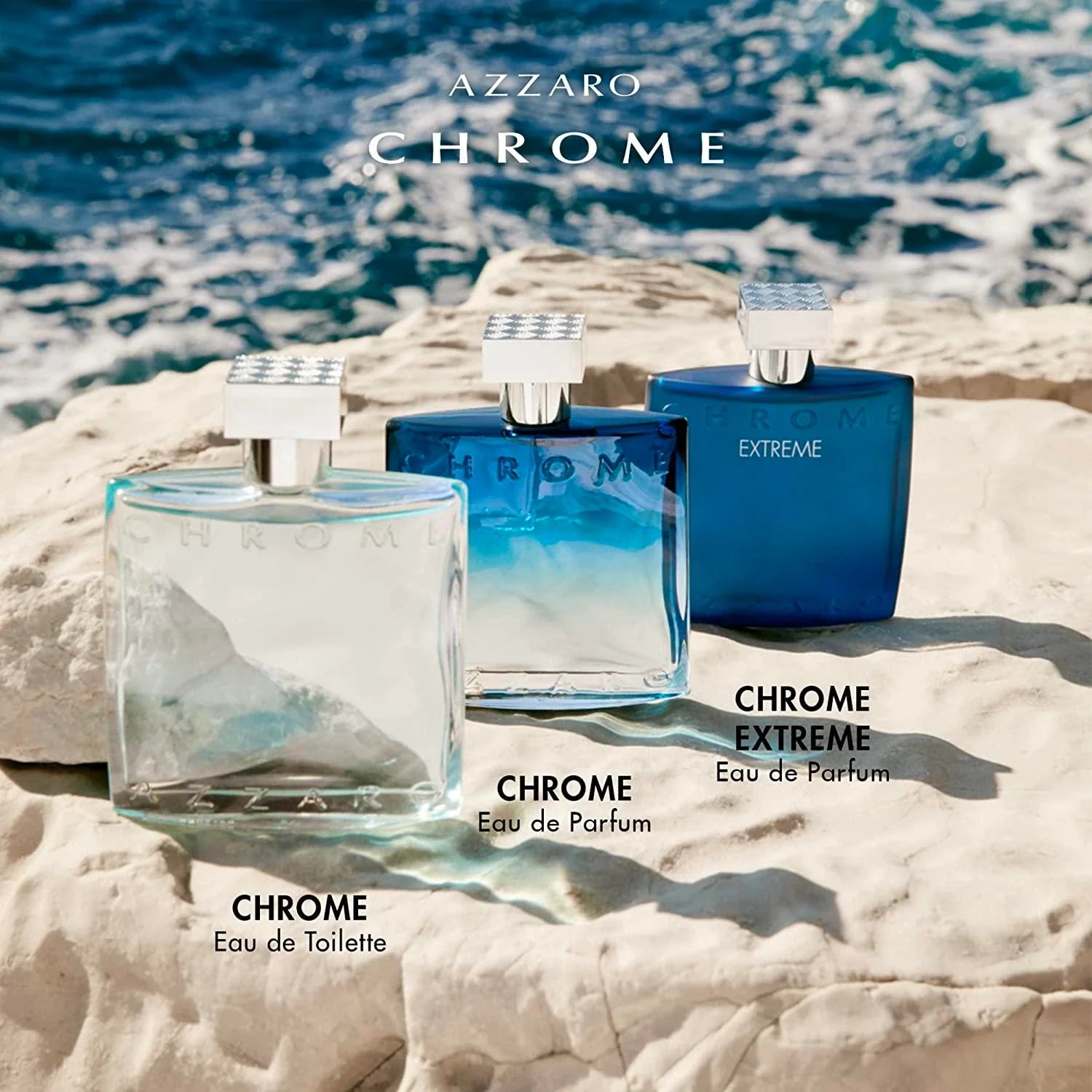 Three Azzaro Chrome perfume bottles on a beach with ocean in the background