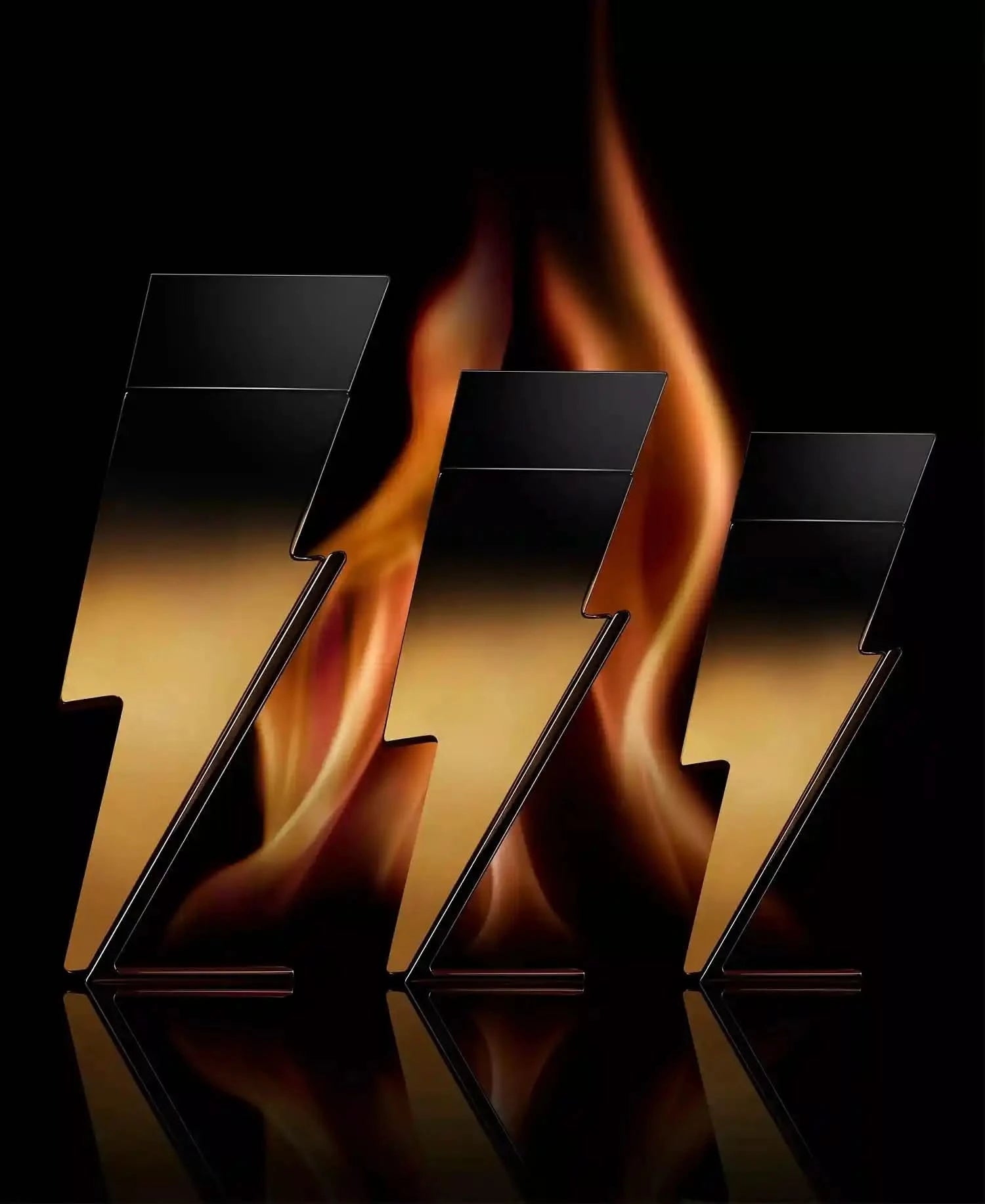 Three metallic plates with flame design on a black background