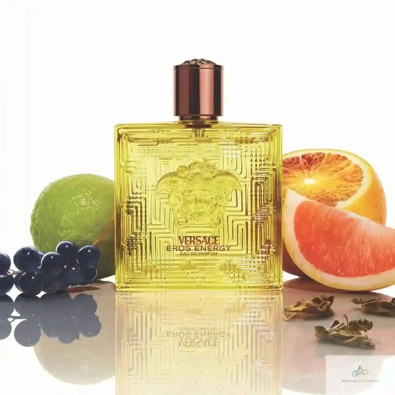 Versace Eros Energy perfume bottle with fruits on a reflective surface