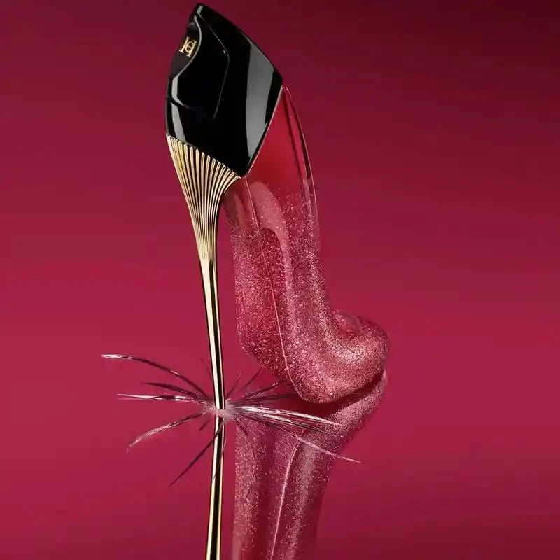 Red high-heeled shoe with gold heel on a reflective surface against a red background