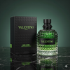 Valentino perfume bottle and packaging on a reflective surface with a green gradient background