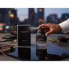 Valentino perfume bottle and packaging on a reflective surface with a blurred cityscape background
