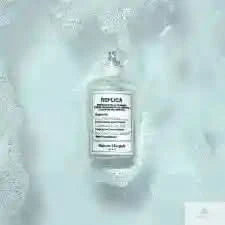 Maison Margiela Replica Bubble Bath EDT bottle resting in foamy bath water, emphasizing its clean, soap-inspired perfume notes for women.