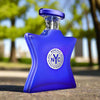 Blue perfume bottle with 'NYC' label on a blurred outdoor background