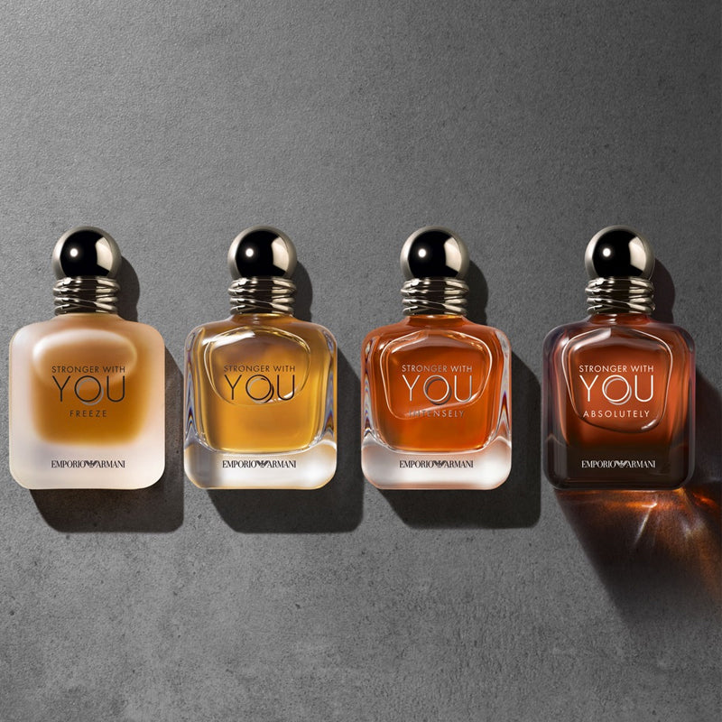 Four Emporio Armani perfume bottles of varying sizes on a gray background