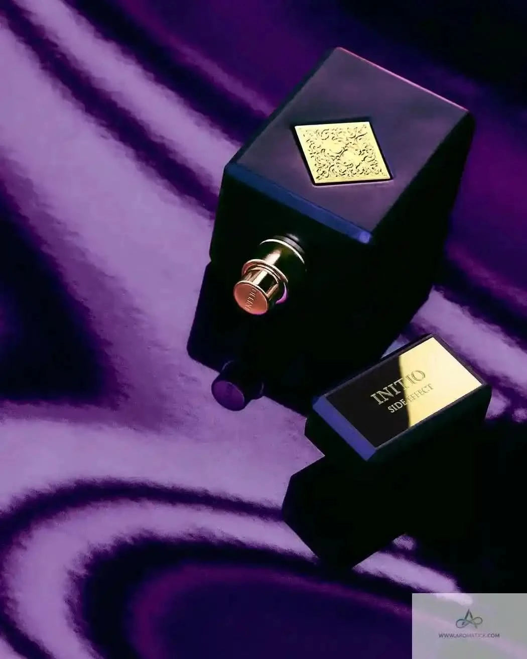 Initio Side Effect EDP bottle with cap removed on purple satin, emphasizing its sensual and intoxicating fragrance character.