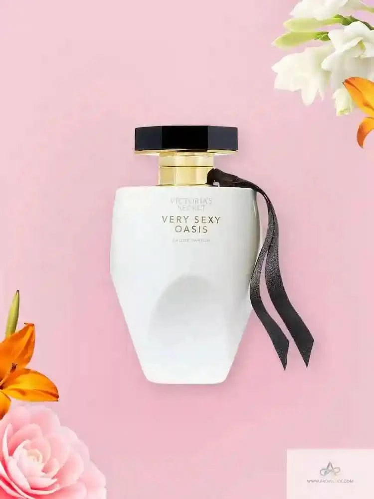 Victoria's Secret 'Very Sexy Oasis' perfume bottle on a pink background with flowers.