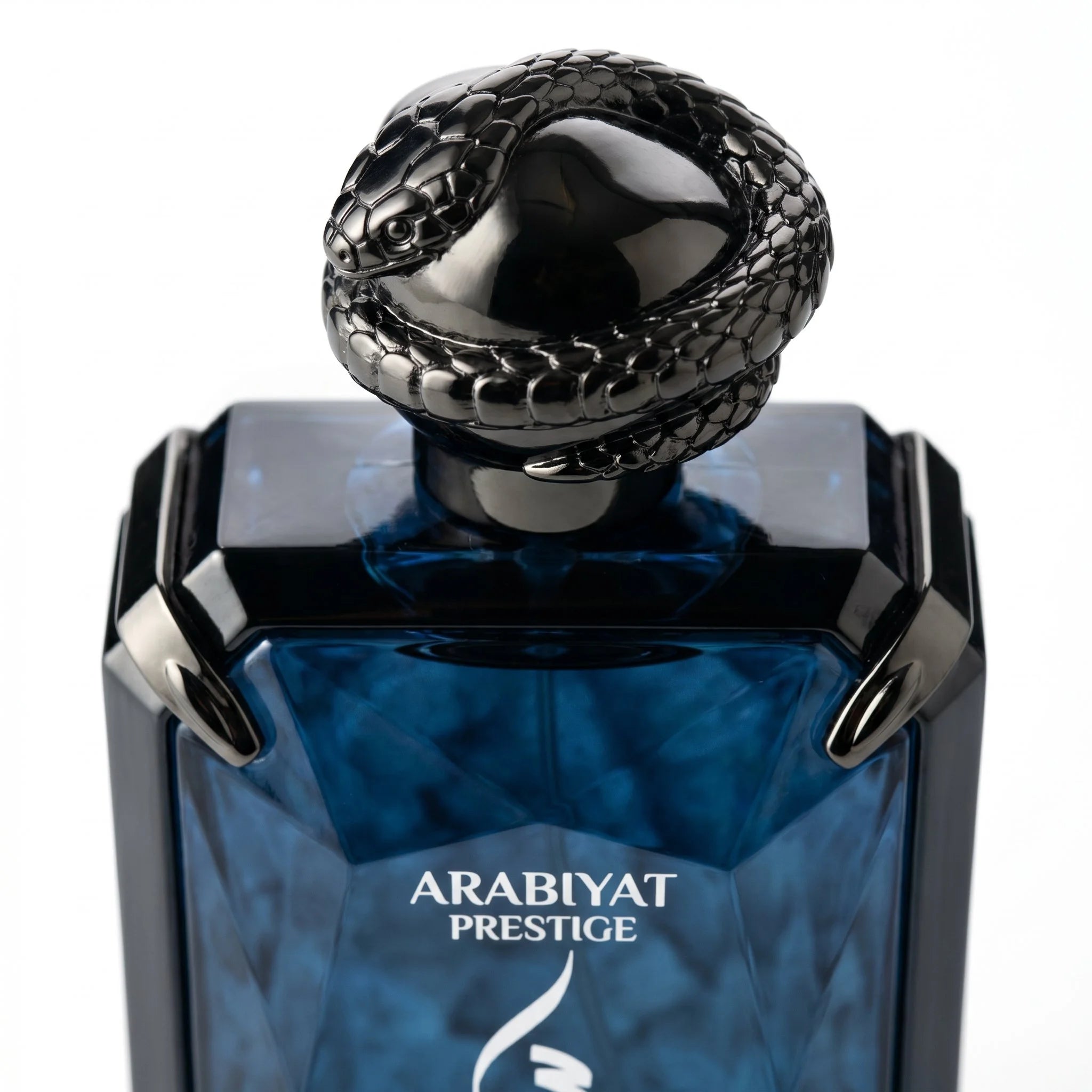 Arabiyat Prestige Swar Séduire coiled snake cap closeup on deep blue faceted crystal bottle