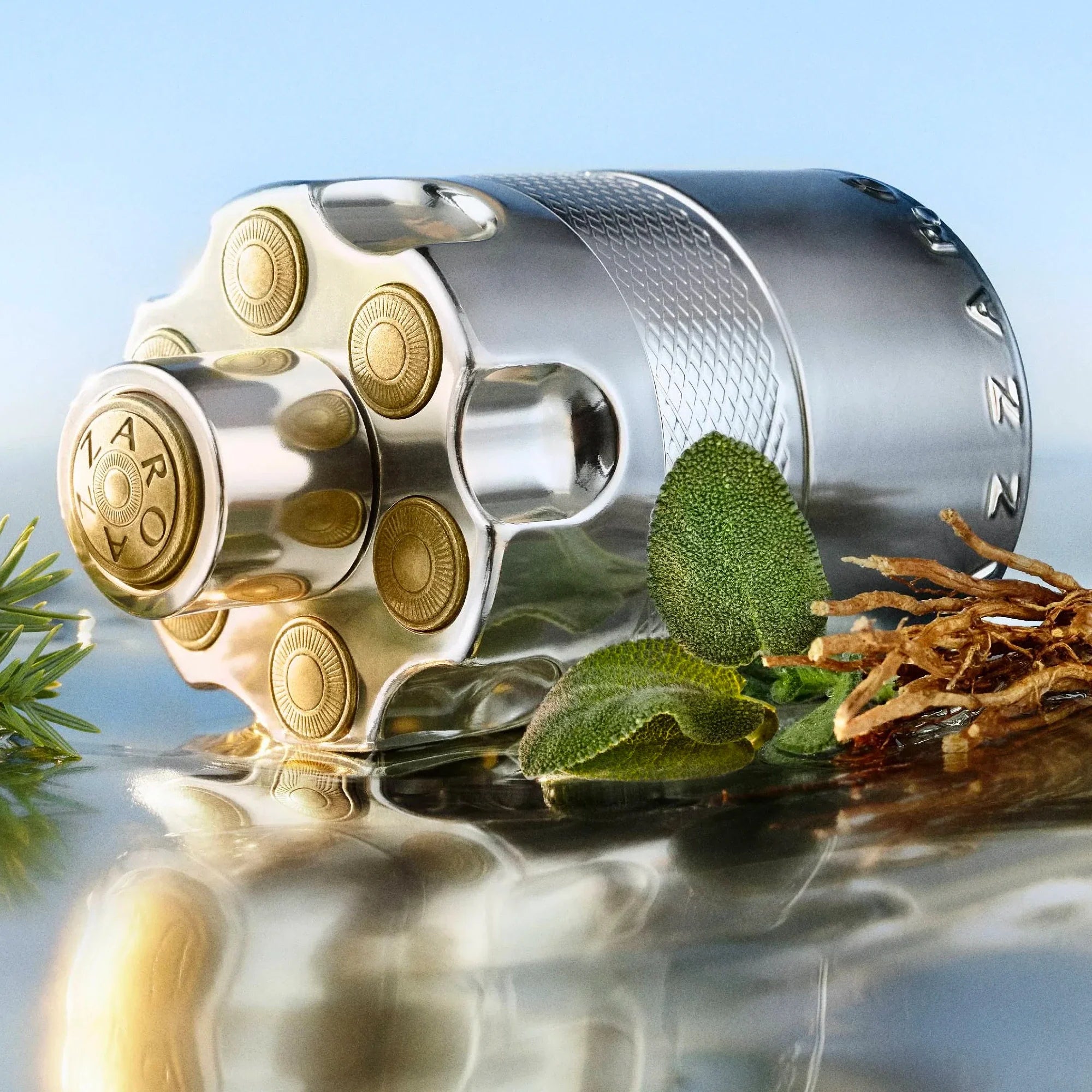 Silver and gold cylindrical product with leaves and tobacco on a reflective surface