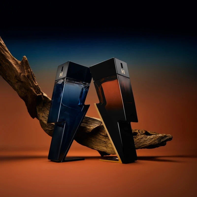 Two black perfume bottles on a wooden surface with a gradient background