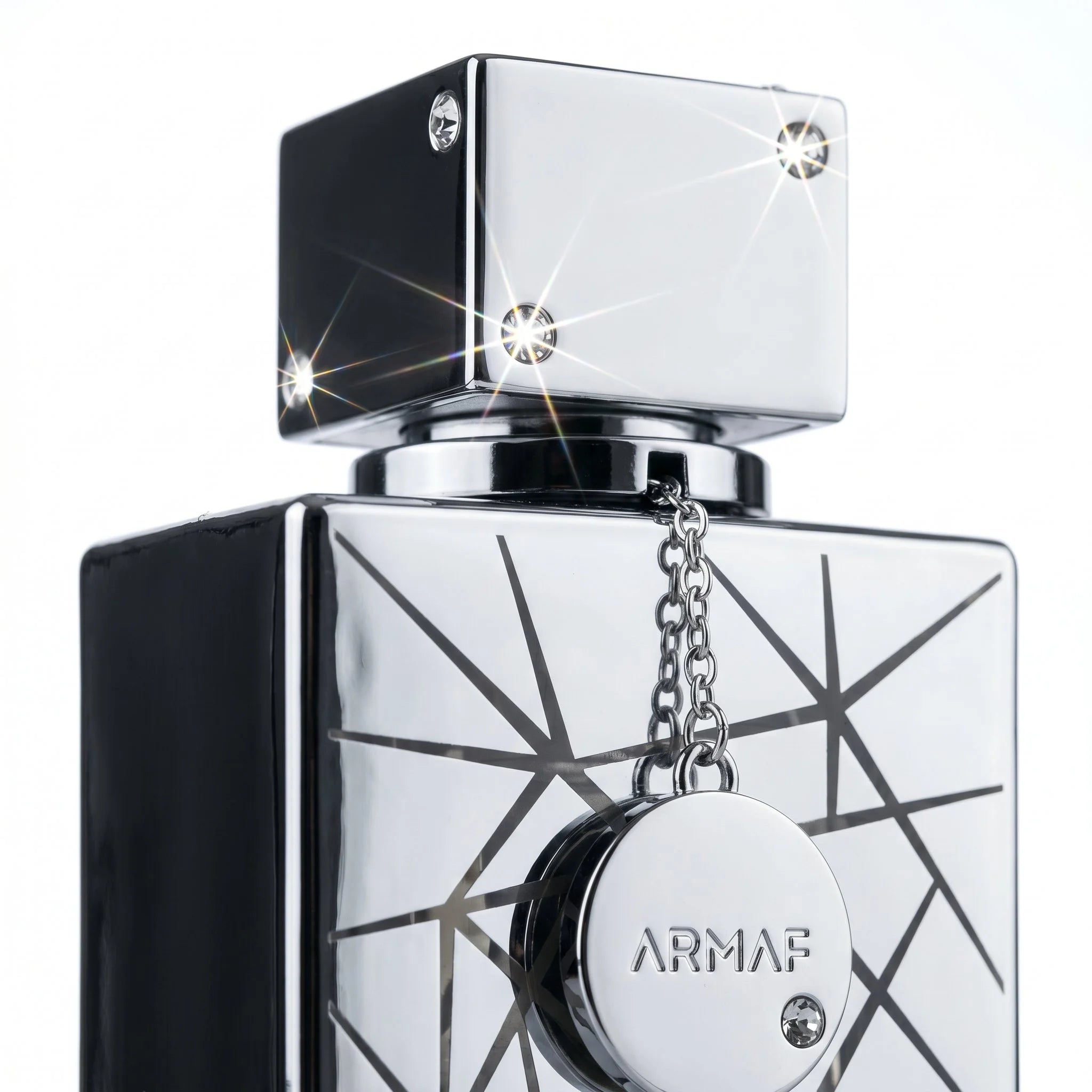 Close-up of Armaf Club de Nuit Sillage chrome cap crystal rivets and ARMAF disc pendant detail