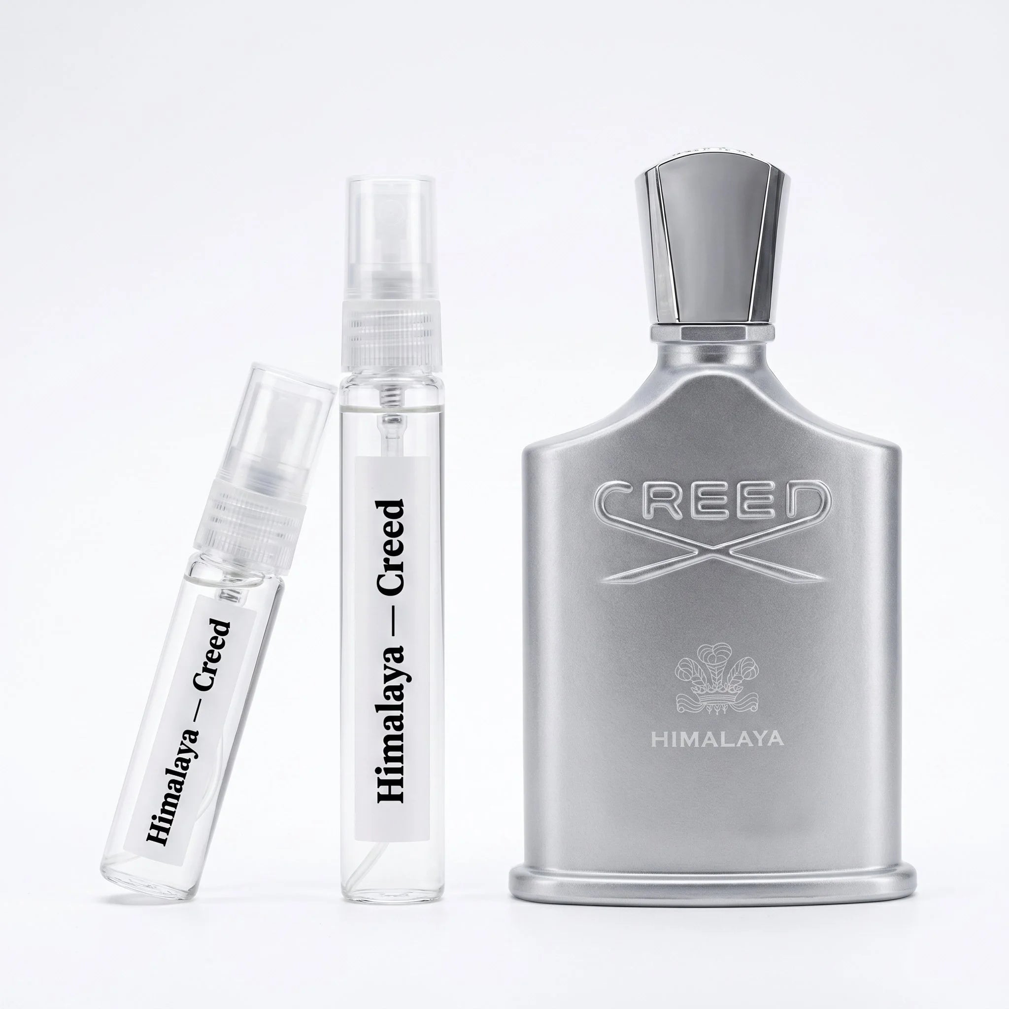 Creed Himalaya decant vials with brushed silver metallic bottle on white background luxury niche fragrance photography