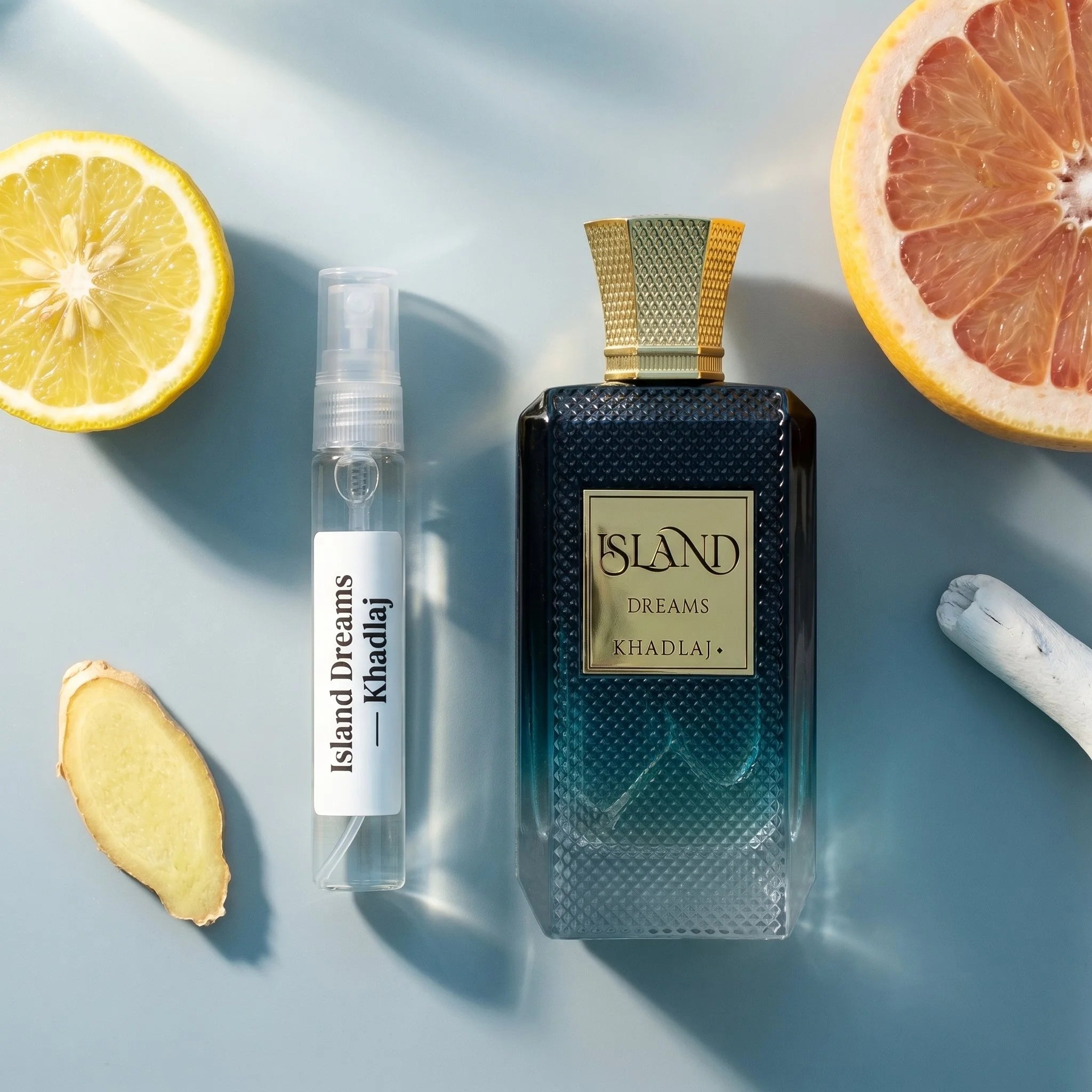 Khadlaj Island Dreams bottle and decant on coastal stone with bergamot ginger grapefruit musk ambroxan fragrance notes flatlay