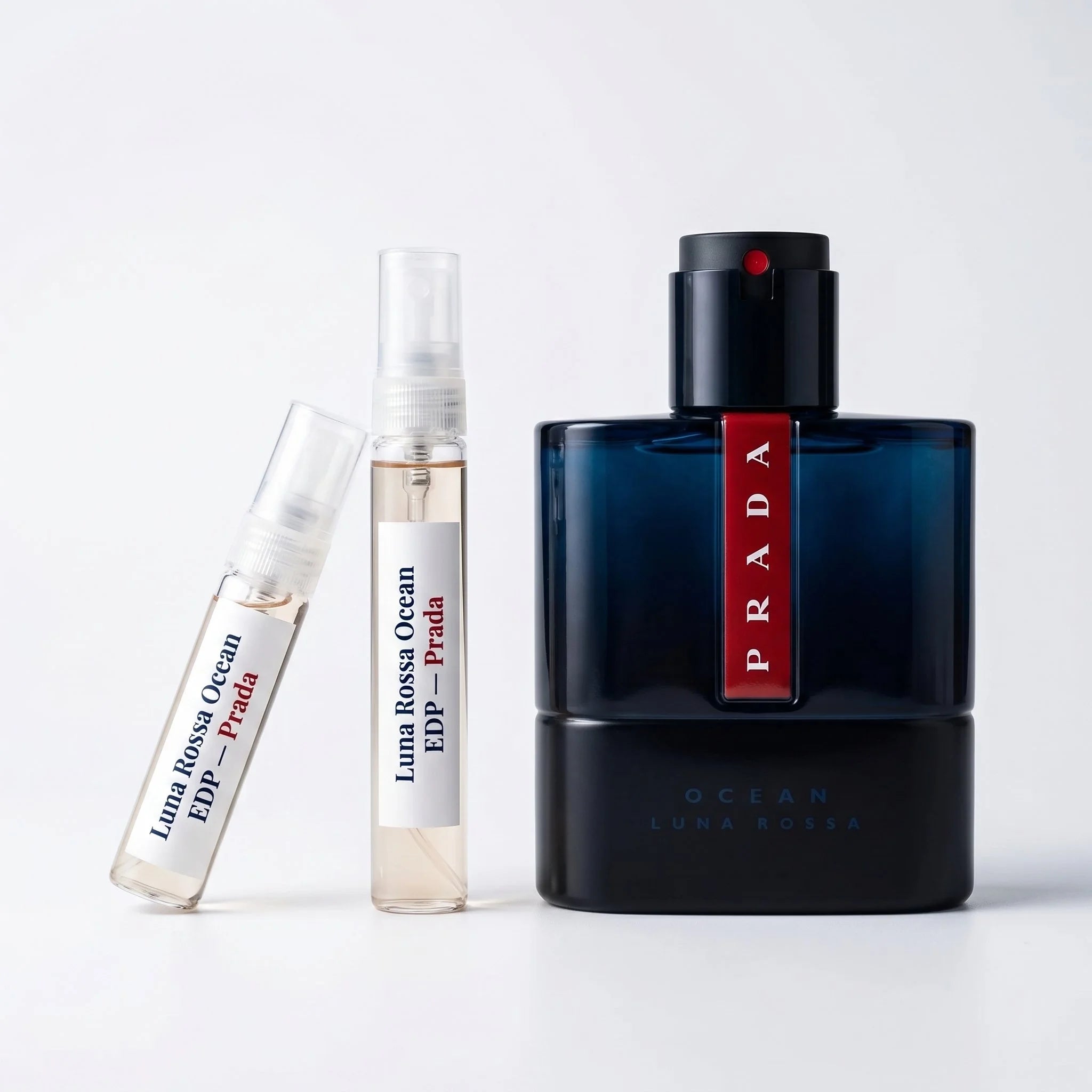 Prada Luna Rossa Ocean EDP decant vials with full bottle on white background luxury fragrance product photography