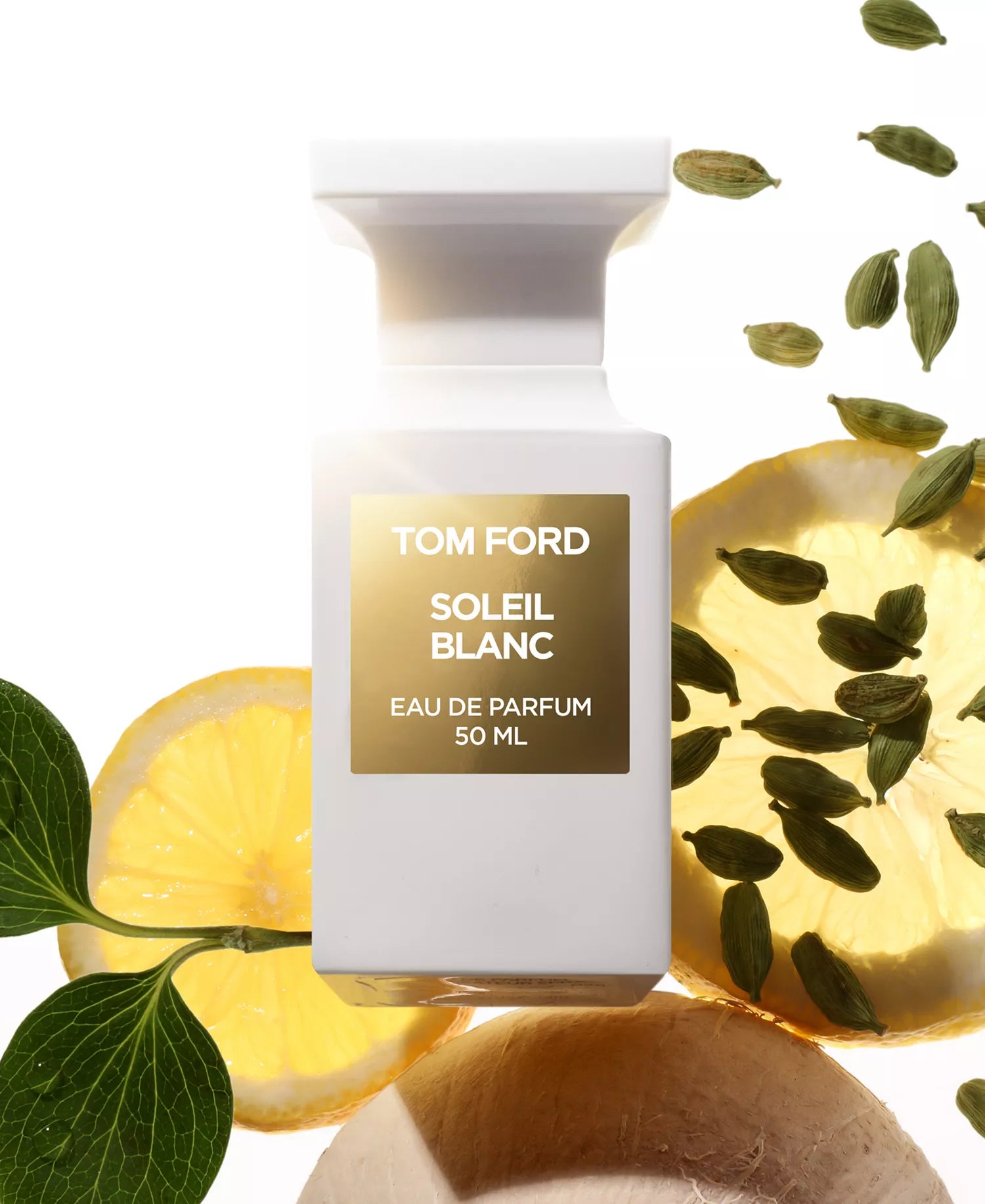 Tom Ford Soleil Blanc perfume bottle with lemons and cardamom pods on a white background