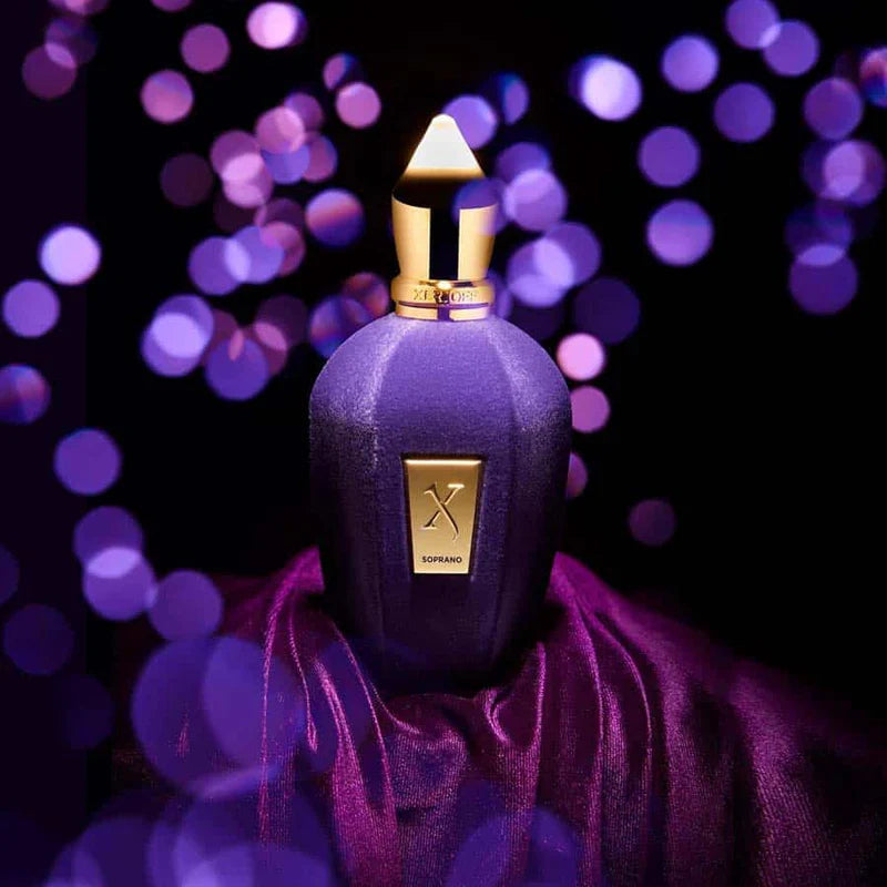 Purple perfume bottle with gold cap on a dark background with purple bokeh lights