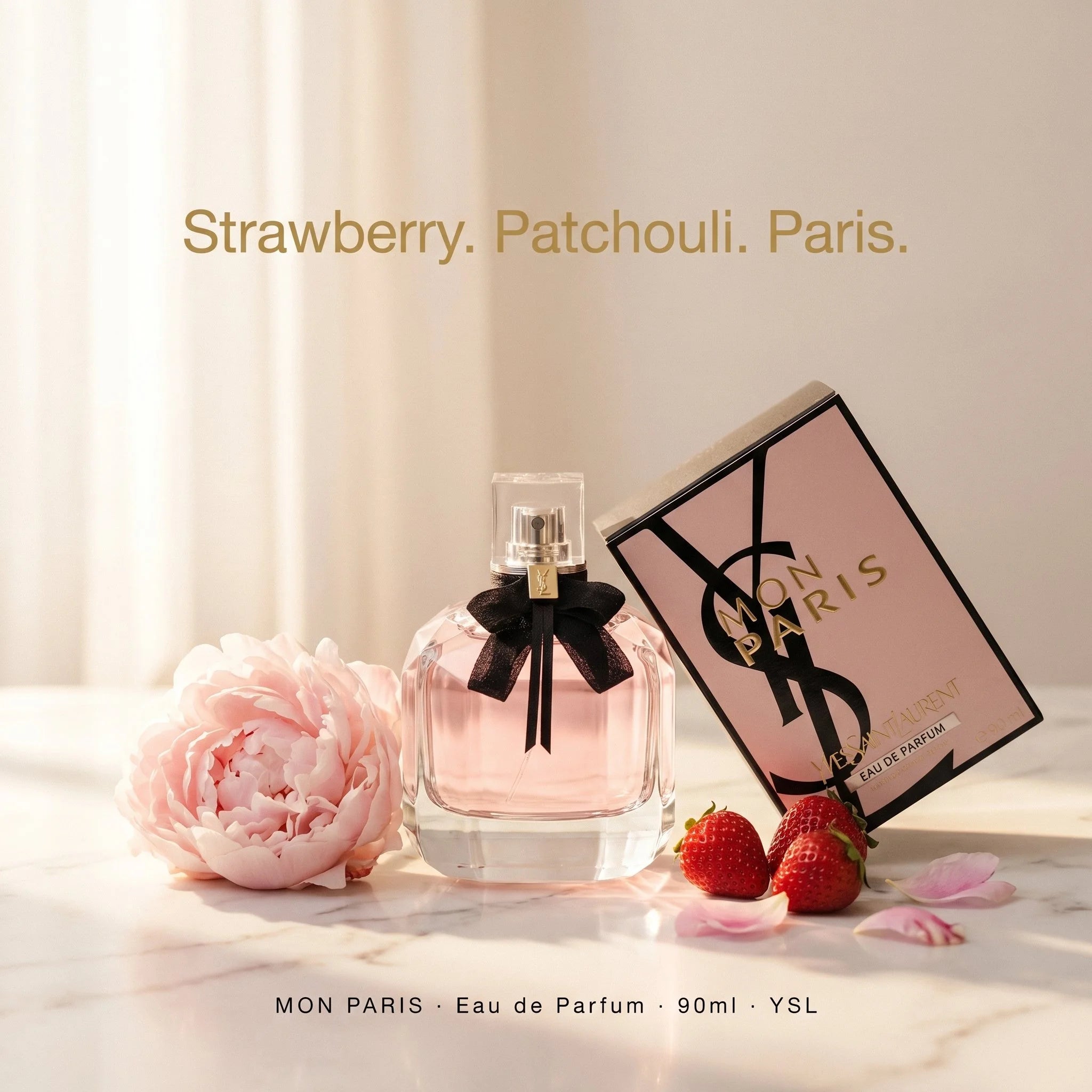 YSL Mon Paris perfume bottle with packaging and strawberries on a light background