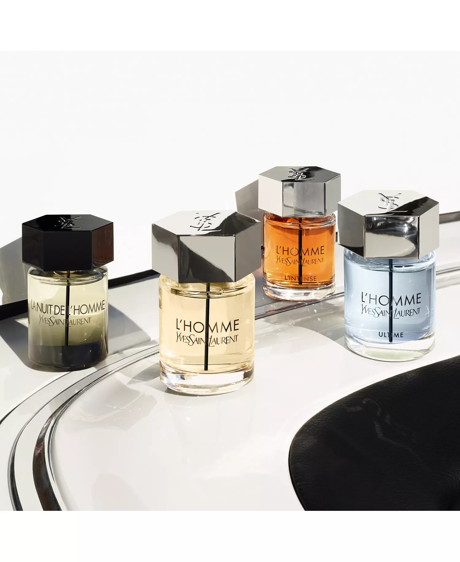 Yves Saint Laurent men's perfume bottles on a reflective surface with a white background
