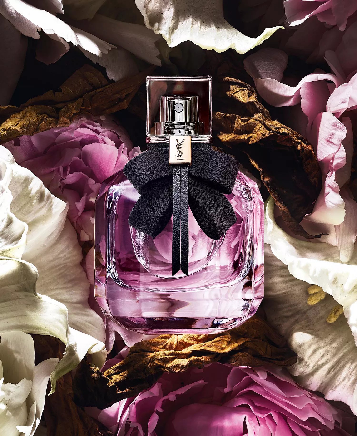 Pink perfume bottle with a black bow on flowers