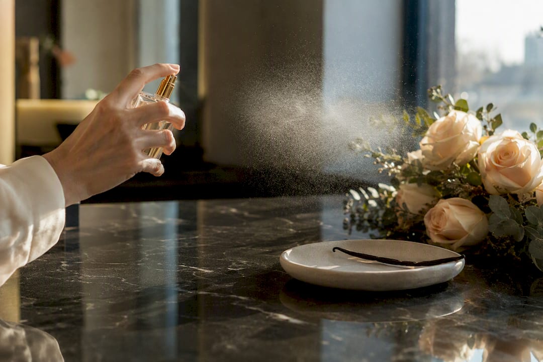 Hand spraying rose vanilla perfume mist