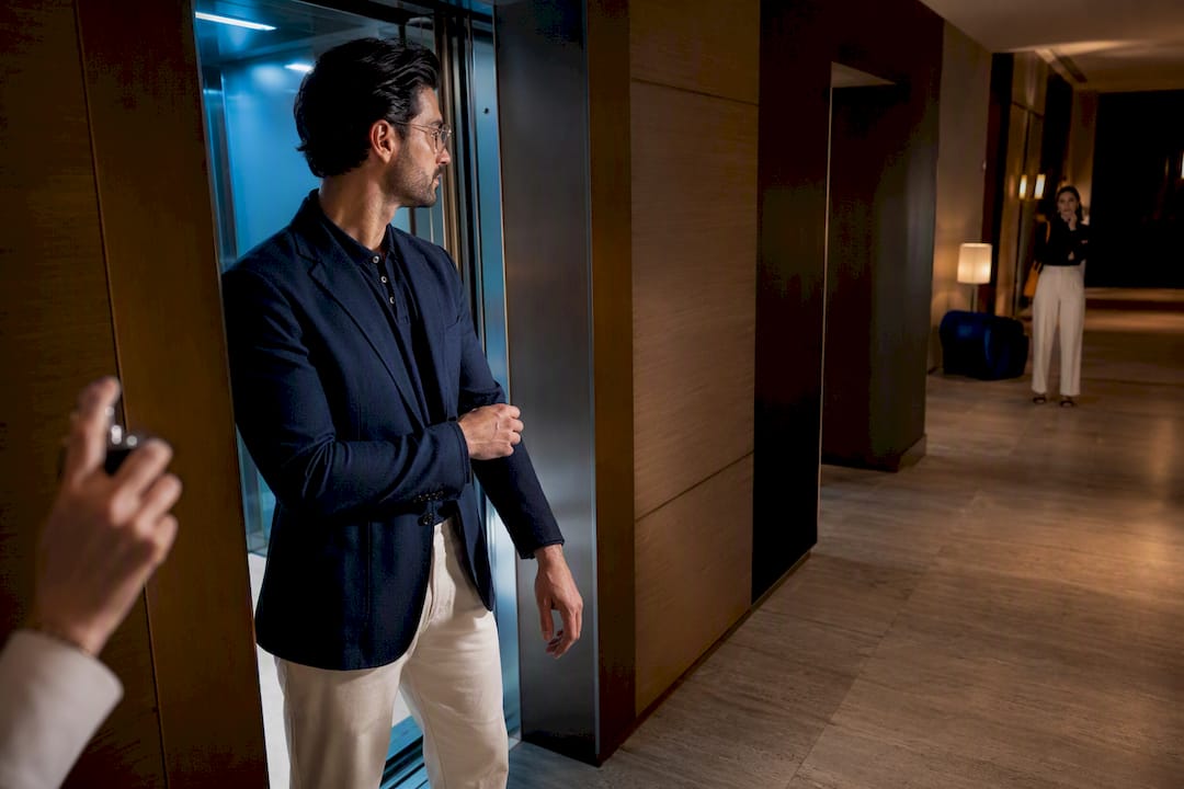 Two people assessing fragrance distance in elevator
