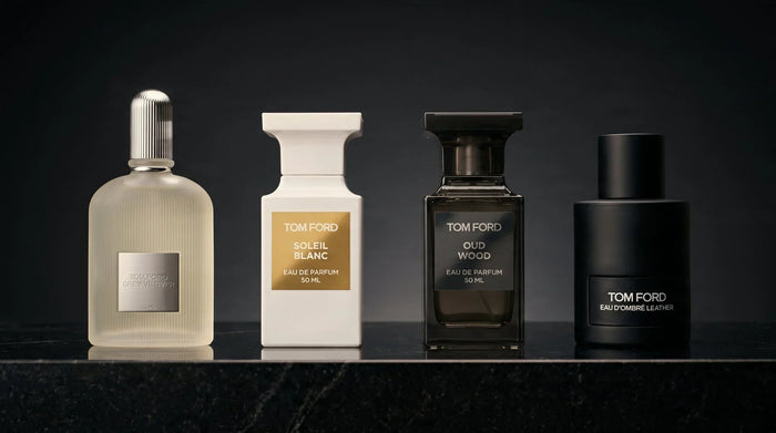 Tom Ford fragrance lineup — Grey Vetiver, Soleil Blanc, Oud Wood, Eau d'Ombré Leather on black granite
