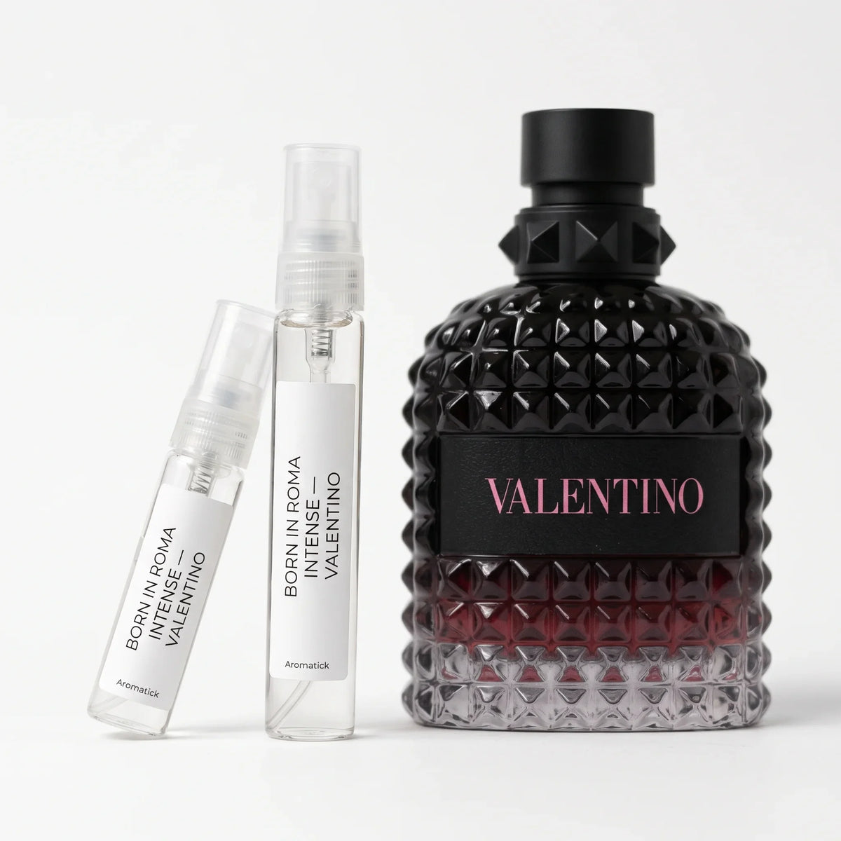 Valentino Born in Roma Intense EDP decant 5ml and 10ml atomizers beside the black-to-red studded bottle