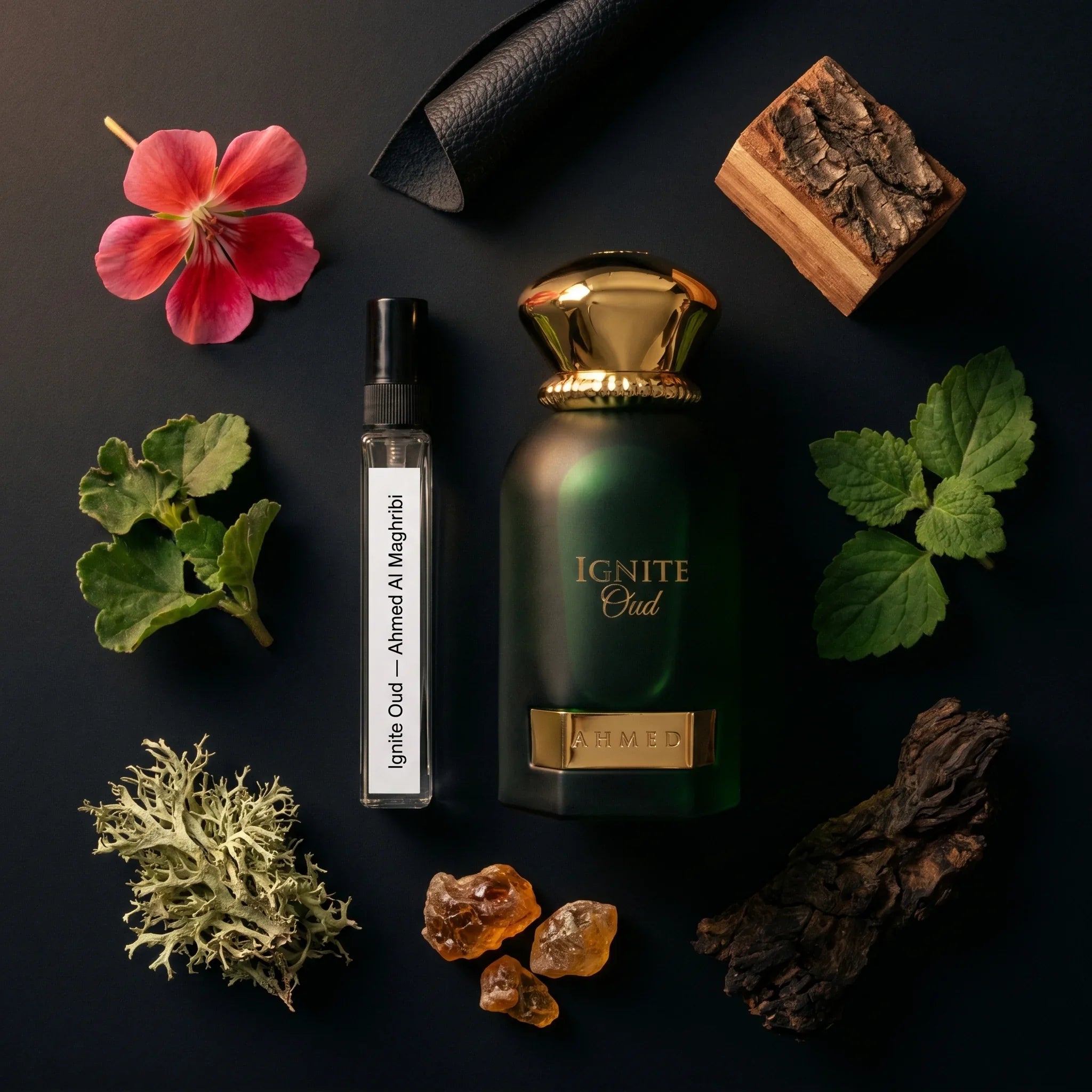 Ahmed Al Maghribi Ignite Oud bottle and Aromatick decant flatlay with geranium leather cedarwood patchouli oakmoss amber sandalwood and oud agarwood fragrance notes on dark surface