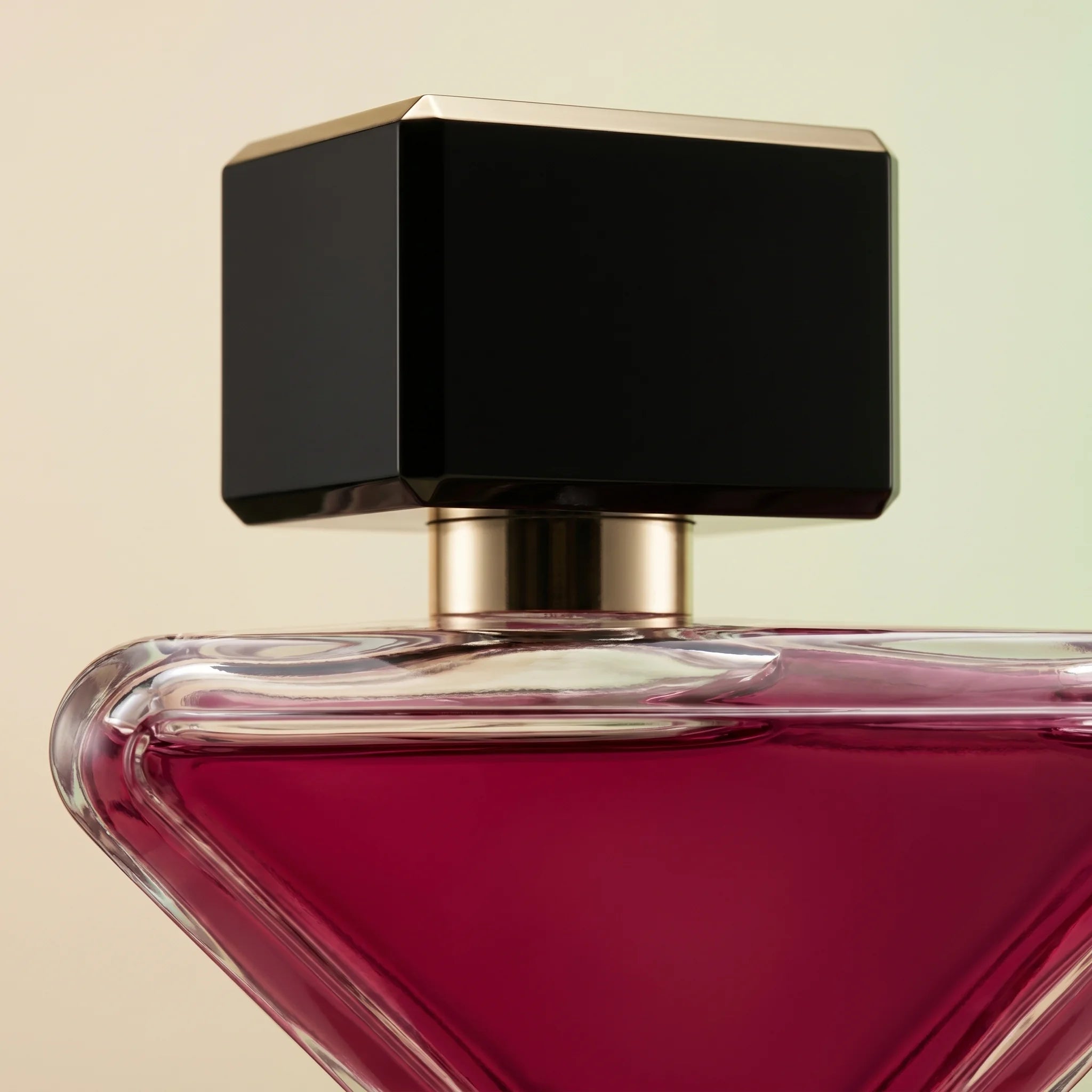 Macro detail of Prada Paradoxe Radical Essence cap and shoulders — black magnetic top with gold accent over deep magenta-red juice
