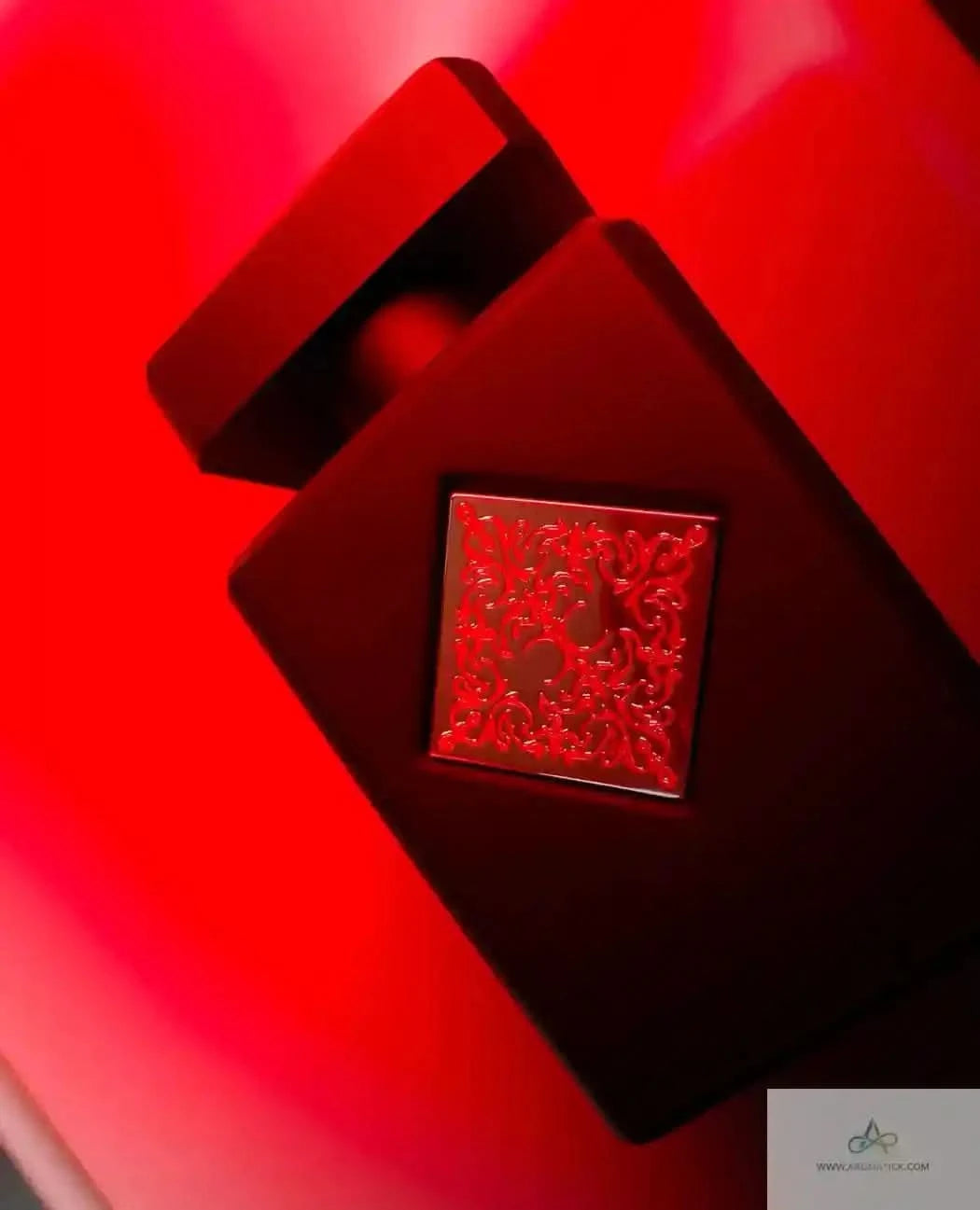 Initio Absolute Aphrodisiac perfume bottle on a red background, highlighting its seductive design and premium unisex scent appeal.