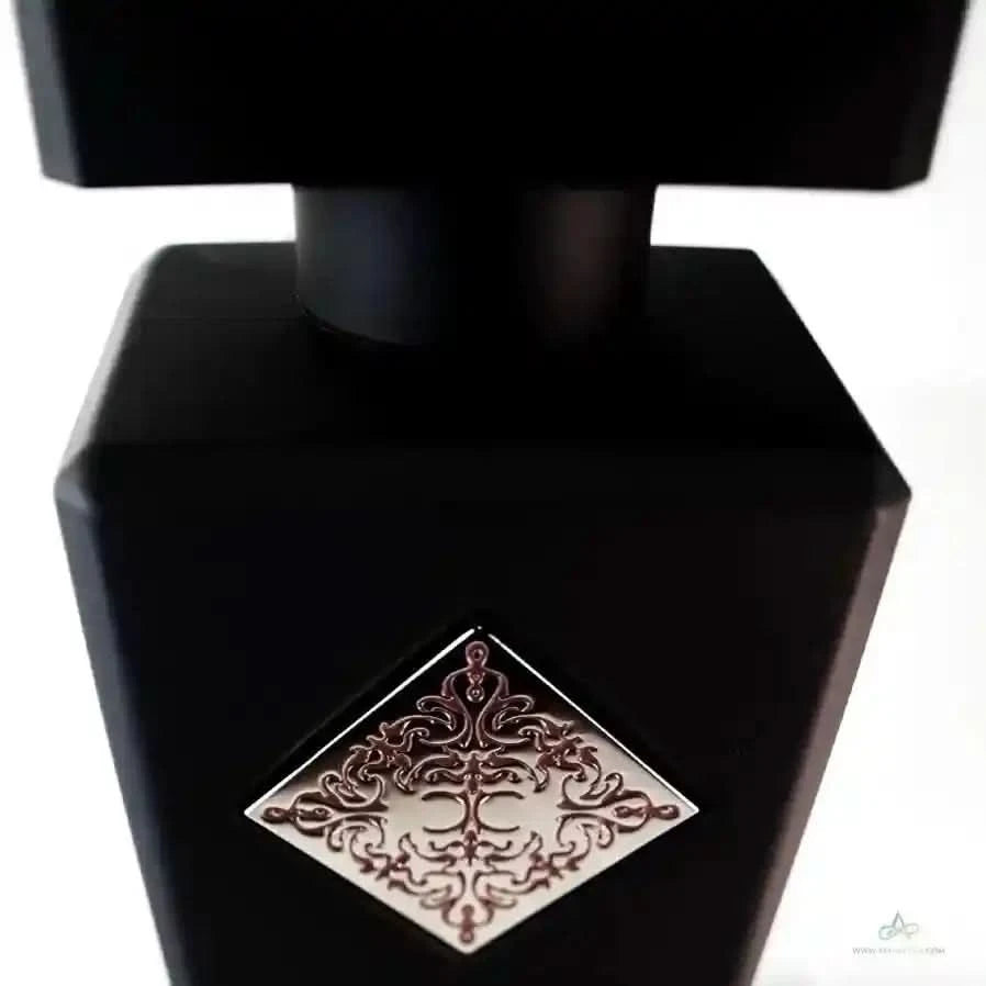 Close-up of Initio Absolute Aphrodisiac perfume bottle showcasing intricate red emblem, a high-end unisex scent from Initio Parfums Prives.