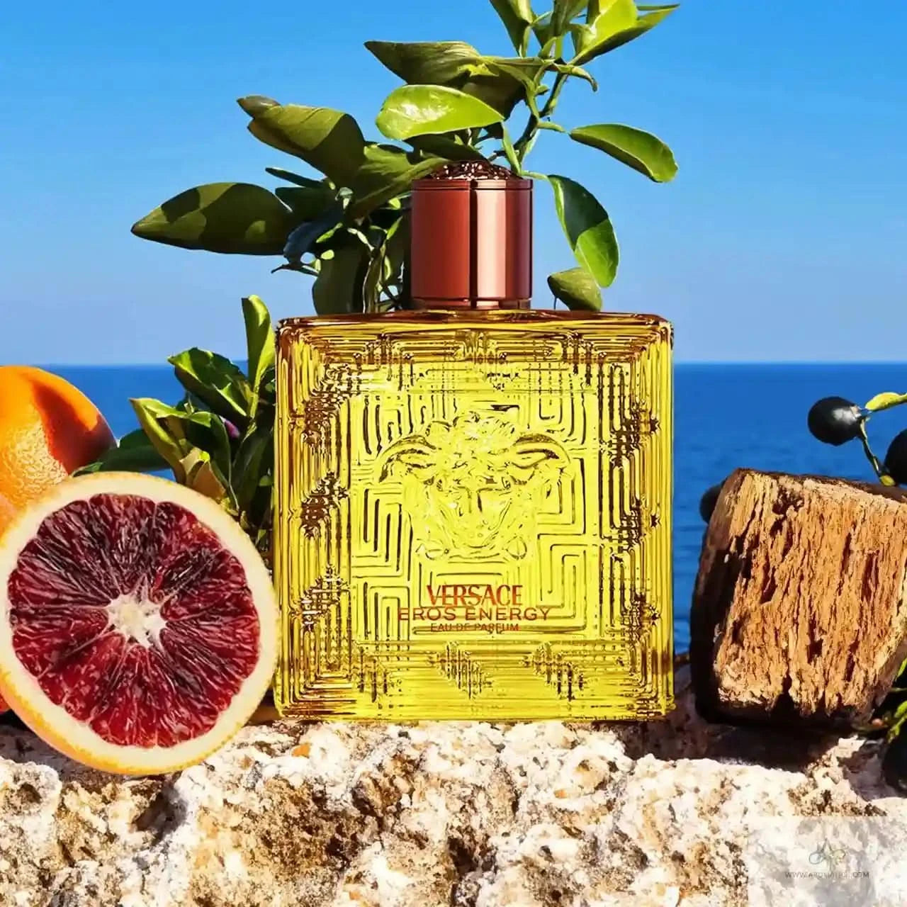 Versace Eros Energy perfume bottle with citrus fruits and ocean view