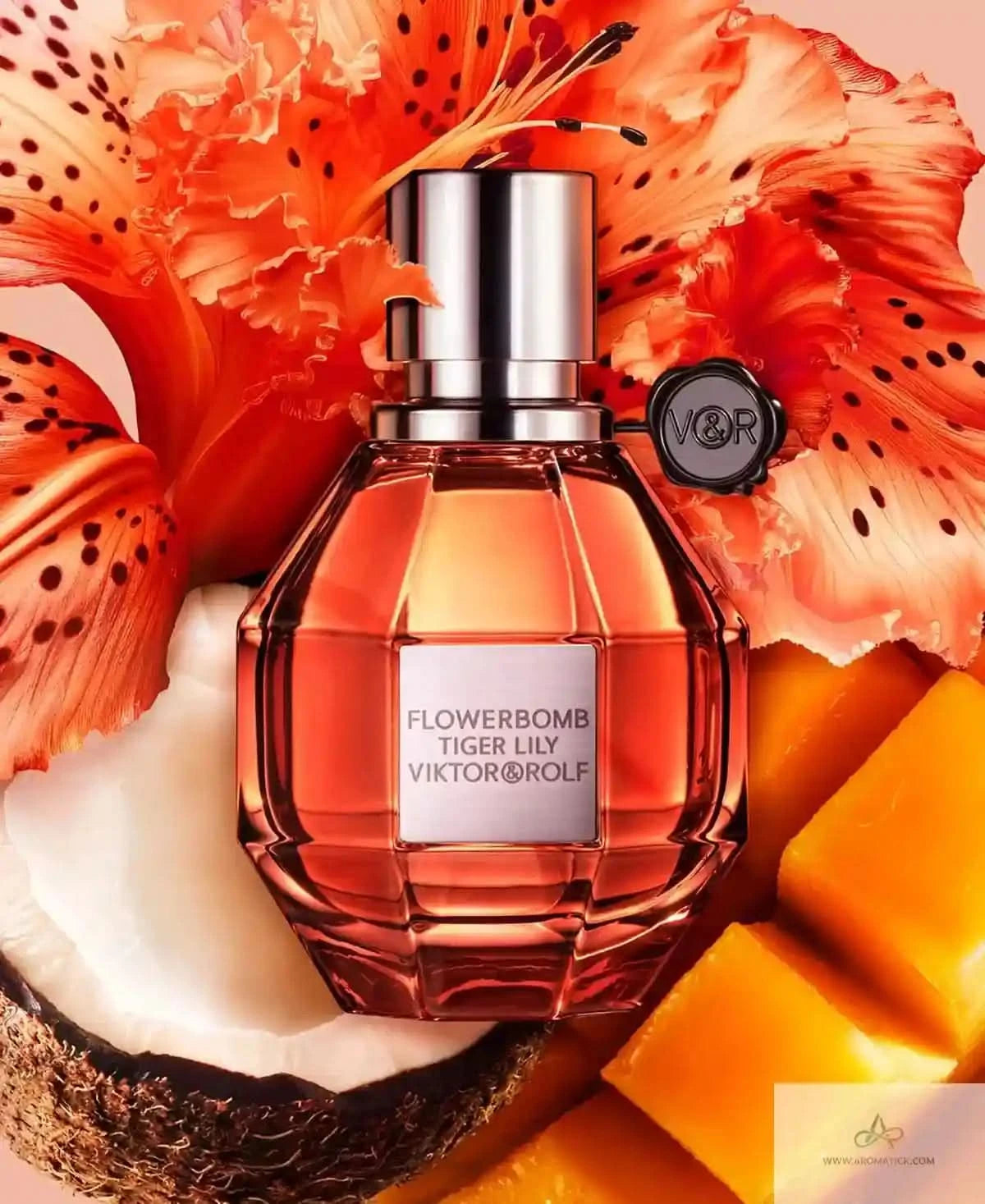 Viktor & Rolf Flowerbomb Tiger Lily perfume bottle with orange flowers and fruit on a beige background