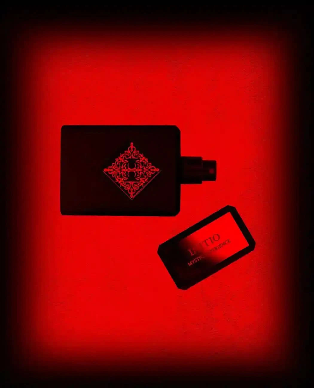 Initio Mystic Experience perfume bottle with cap off, set against a dramatic red background, showcasing its seductive and magnetic scent profile.