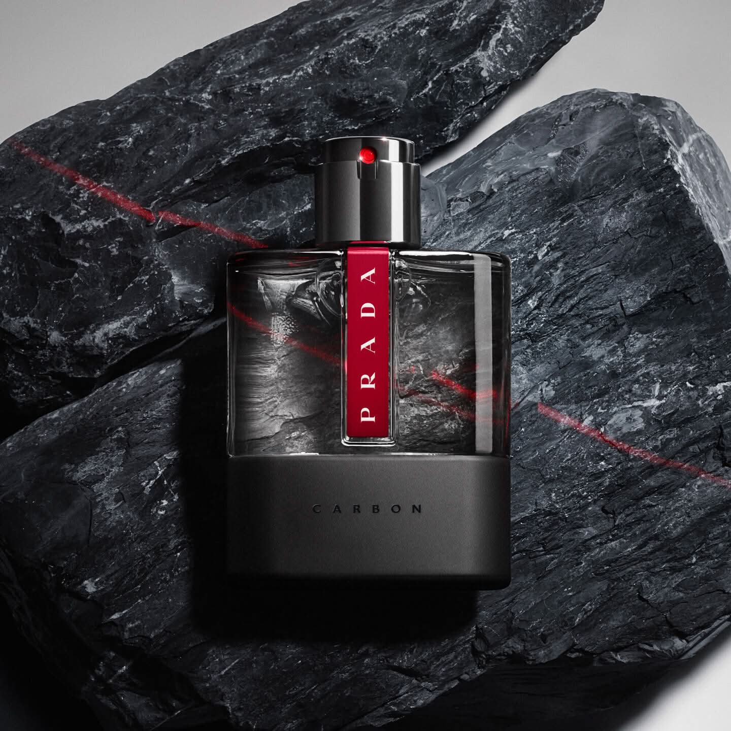 Prada Carbon perfume bottle on a dark stone background