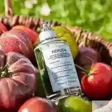 Maison Margiela Replica From the Garden EDT nestled among fresh tomatoes in a basket, showcasing its garden-inspired fragrance profile.
