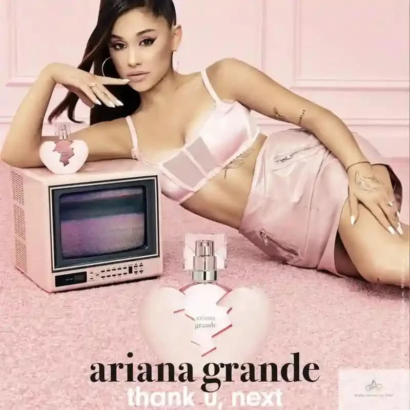 Ariana Grande in a pink outfit with a vintage TV and perfume bottle on a pink background