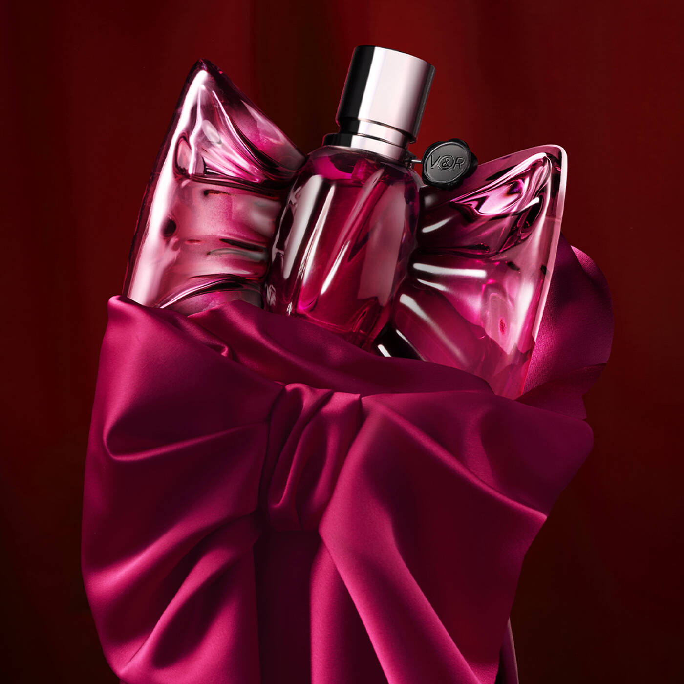 Pink perfume bottle with a large bow on a red background