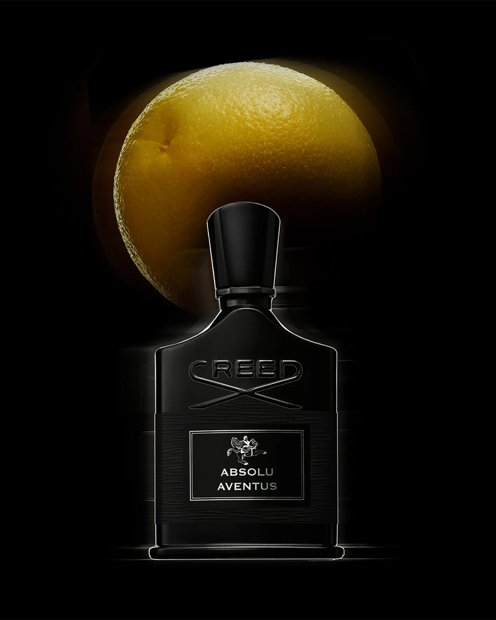 Creed Absolu Aventus perfume bottle with a lemon in the background