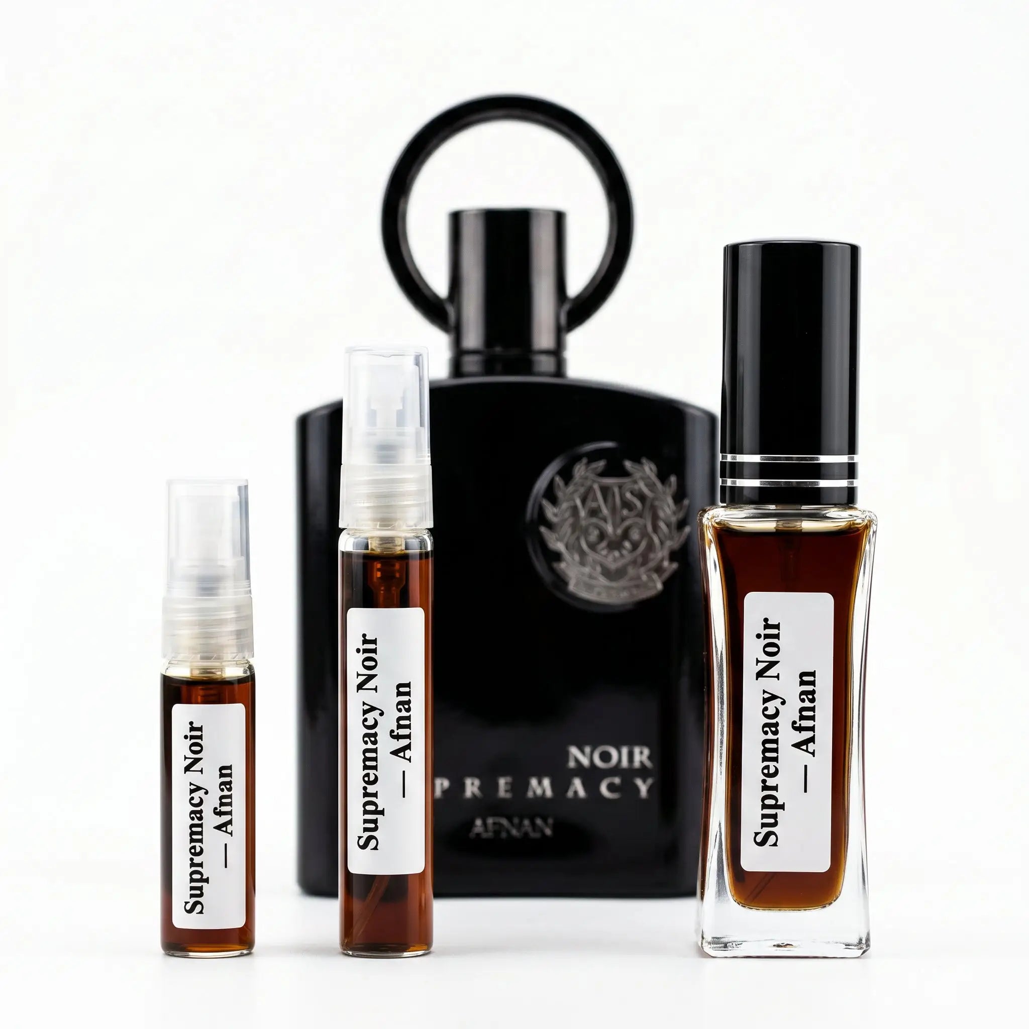 Afnan Supremacy Noir decants next to full matte black bottle with ring cap on white background