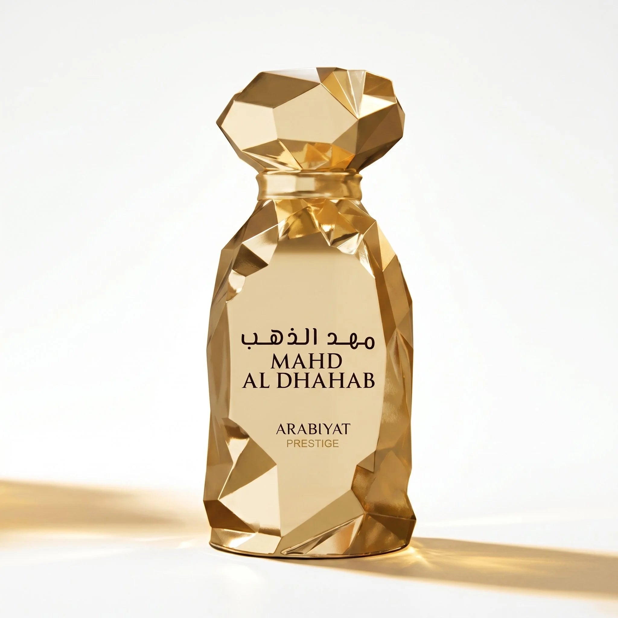 Arabiyat Prestige Mahd Al Dhahab gold geometric faceted EDP bottle on white background

