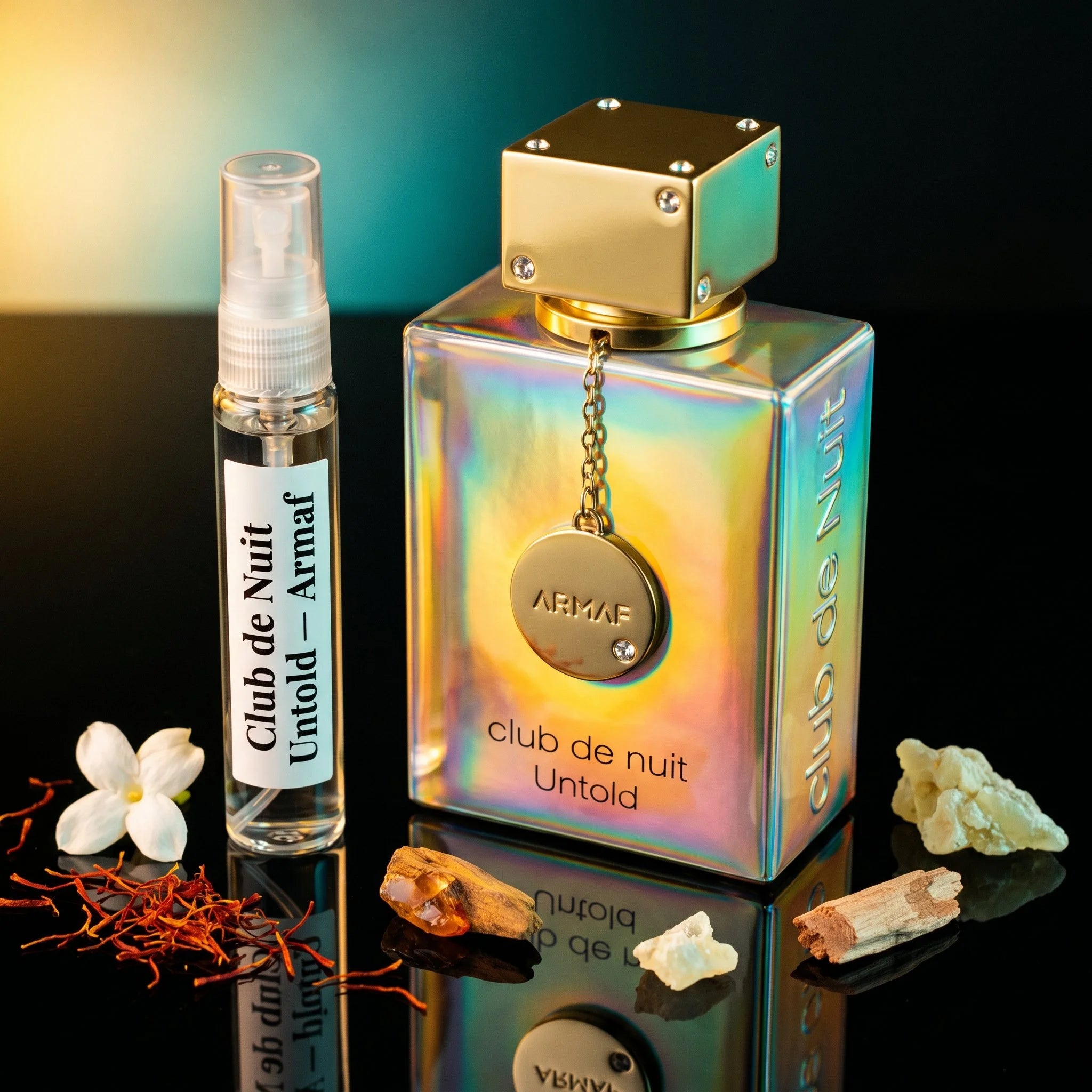 Armaf Club de Nuit Untold bottle and decant on black surface with saffron jasmine amberwood ambergris fir cedar fragrance notes flatlay