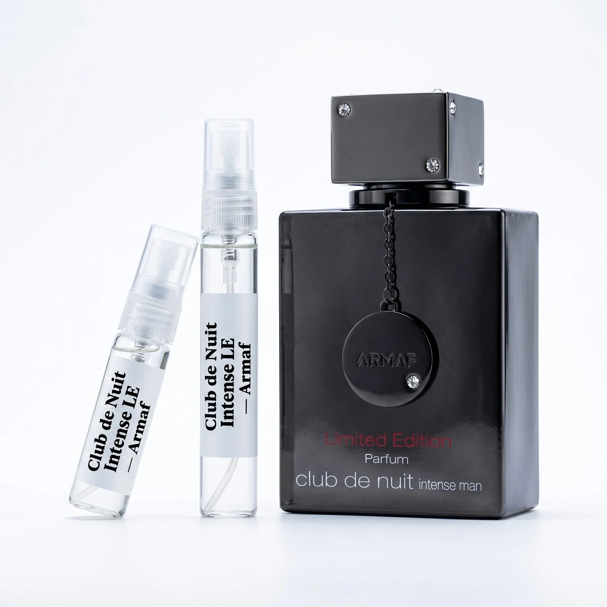 Armaf Club de Nuit Intense Man Limited Edition decant vials with matte black gunmetal bottle on white background luxury fragrance photography