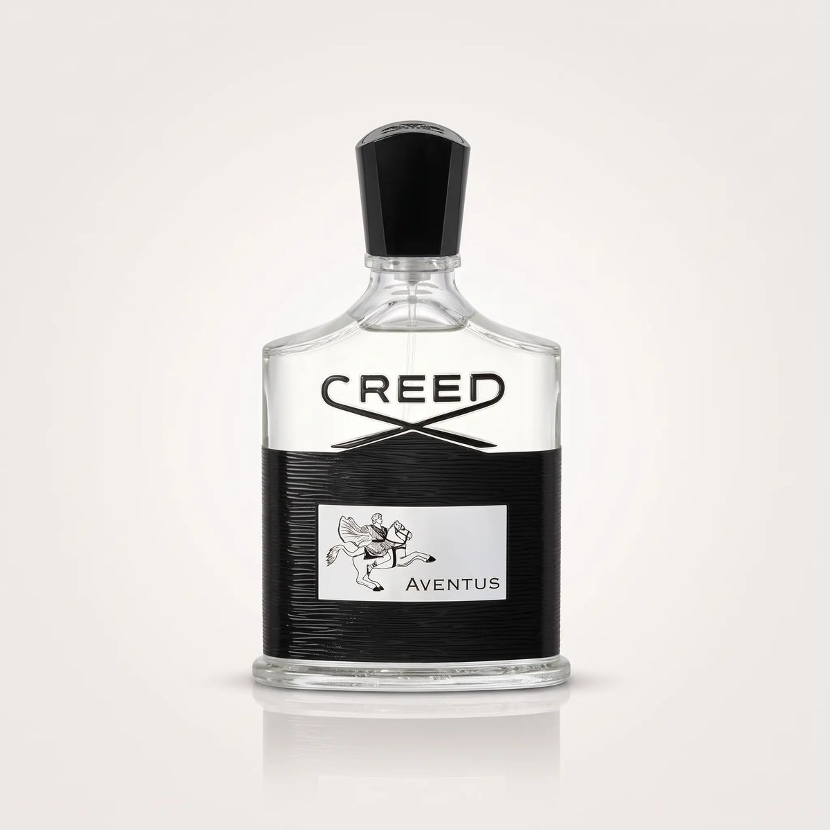Creed Aventus Eau de Parfum bottle with a clear glass body, black cap, and a black textured label featuring the Creed logo and Aventus text.