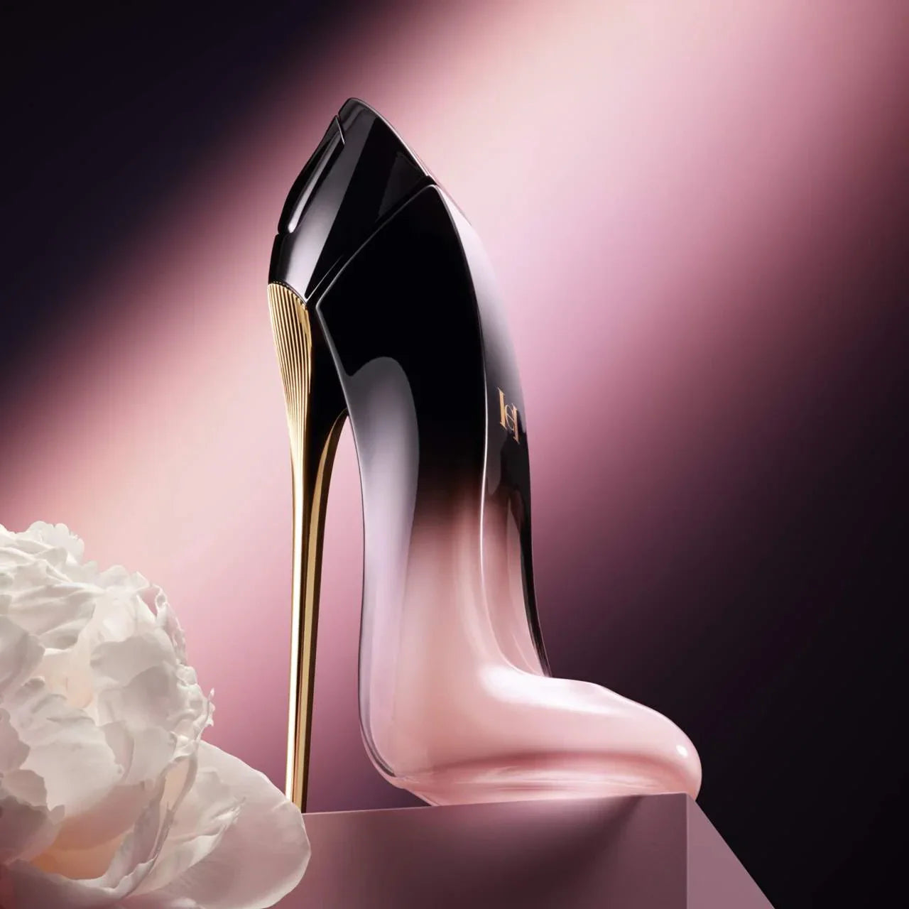 Black and gold high-heeled shoe with a white flower on a pink background