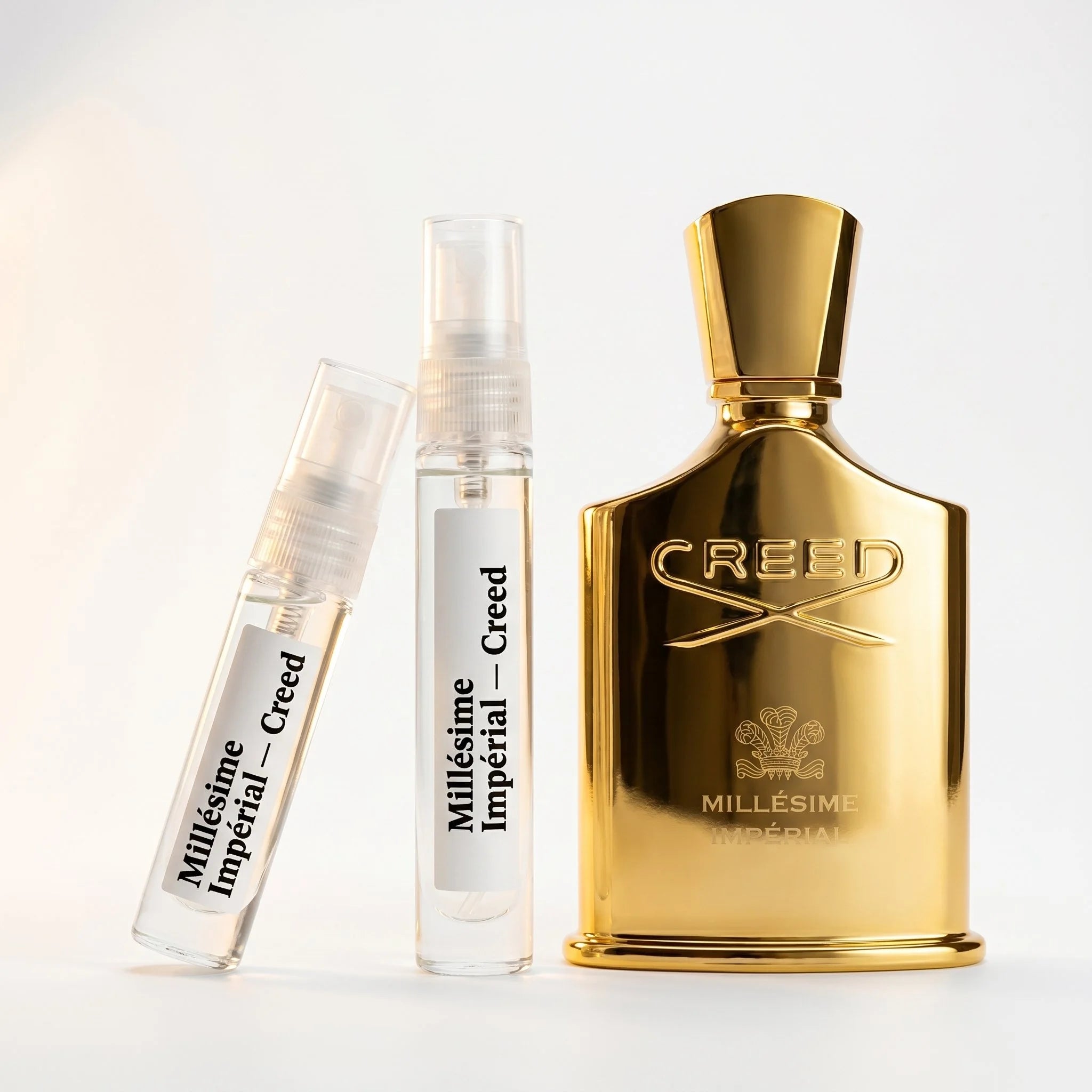 Creed Millesime Imperial decant vials with all-gold bottle on white background luxury niche fragrance photography